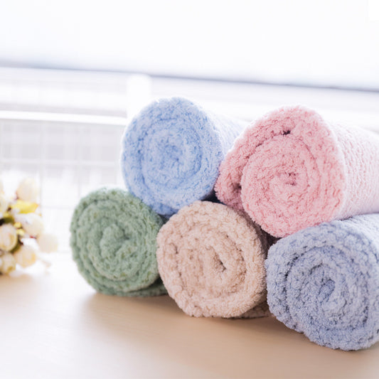 Set of rolled-up colorful towels on a light surface with a blurred background