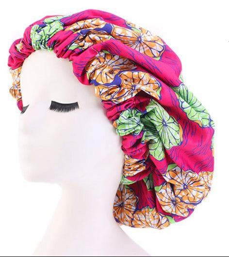 Colorful satin bonnet with floral design on a mannequin head, showing satin lining and elastic band details.