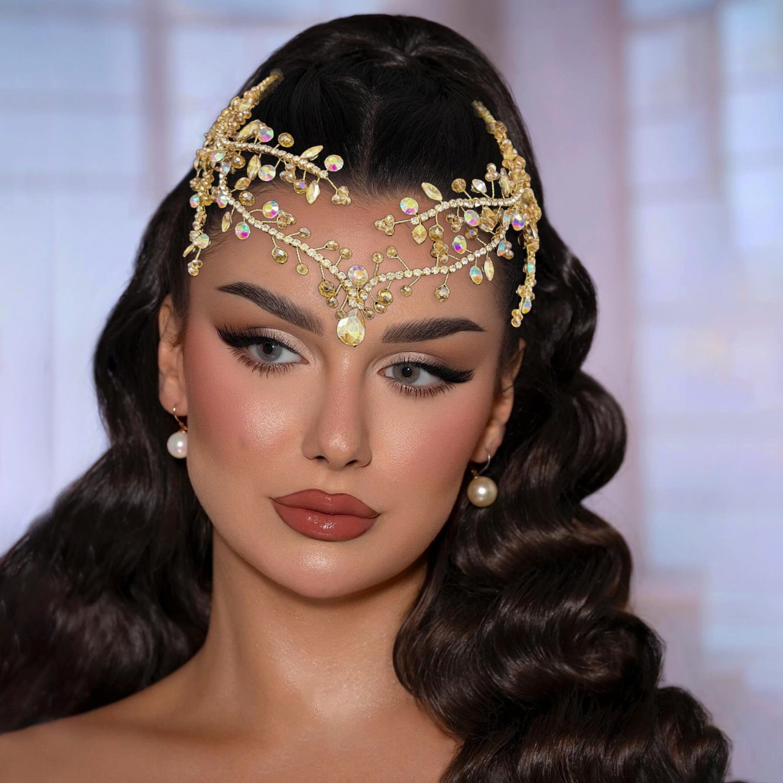 Woman wearing a gold headpiece with gemstones against a blurred background