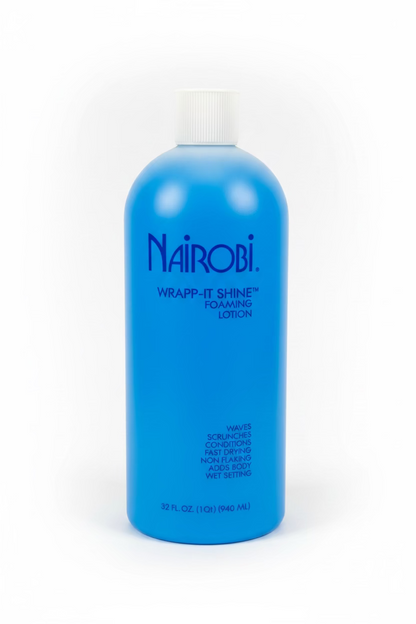 A blue bottle of Nairobi Wrapp-It Shine Foaming Lotion with a white cap, photographed on a white surface with a blurred background.