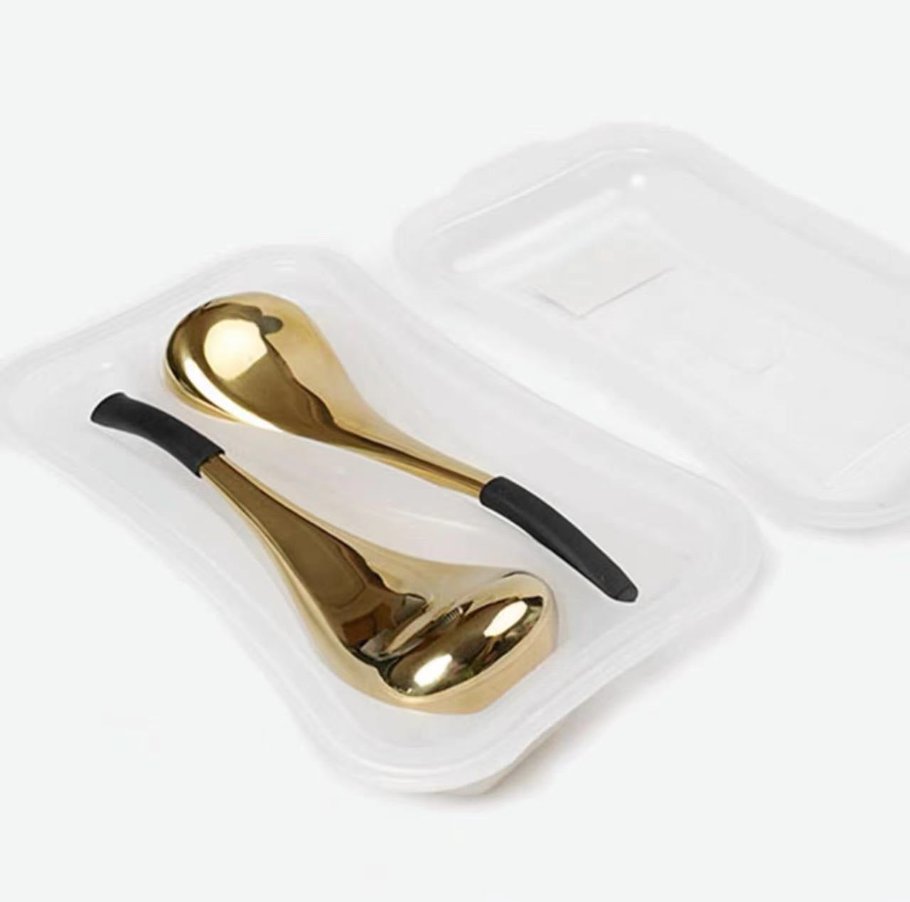 Gold salt and pepper shakers with black handles in a clear plastic packaging on a white background
