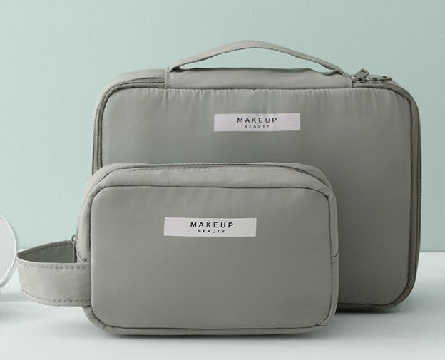 Two gray makeup bags with 'MAKEUP BEAUTY' labels on a light blue background