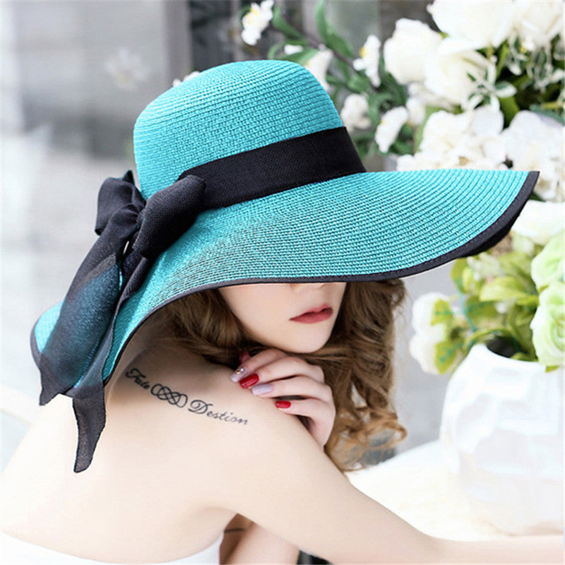 Close-up of woven straw and paper brim with decorative bow accent on sun hat