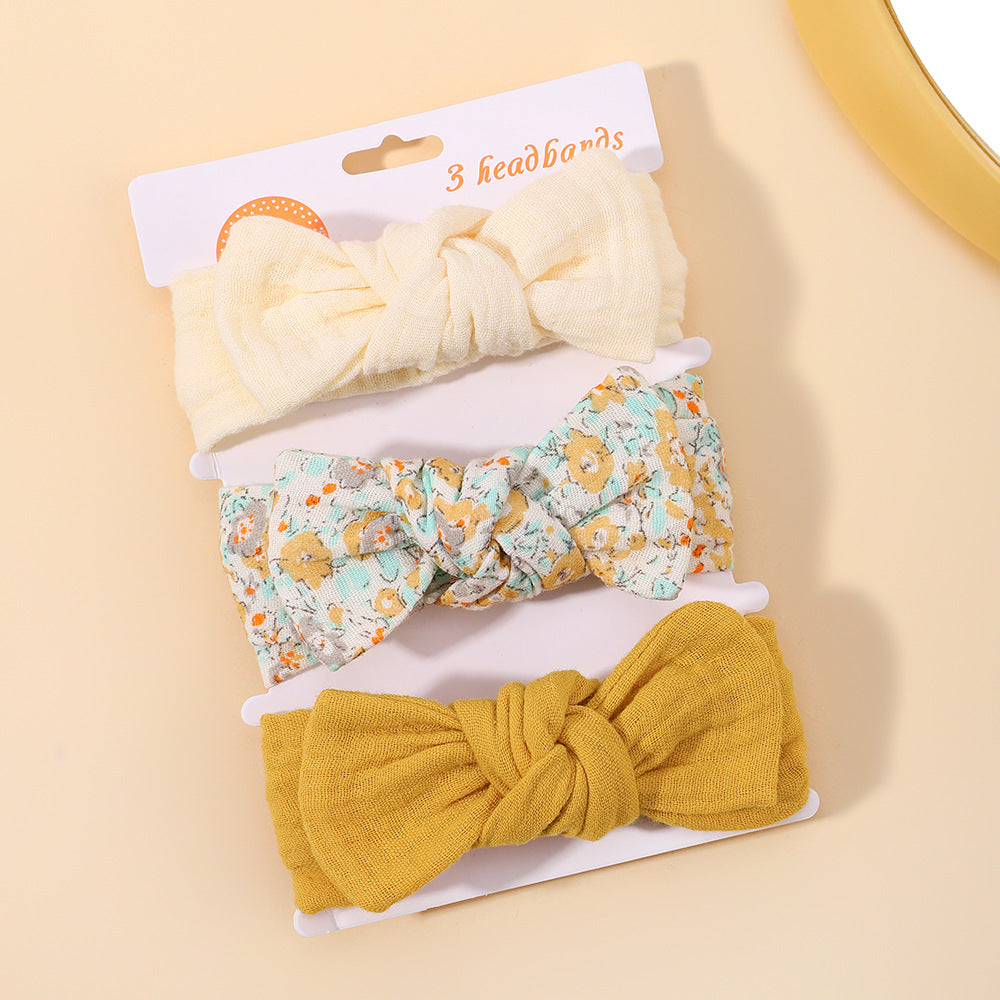 Three headbands with bow designs on a beige background